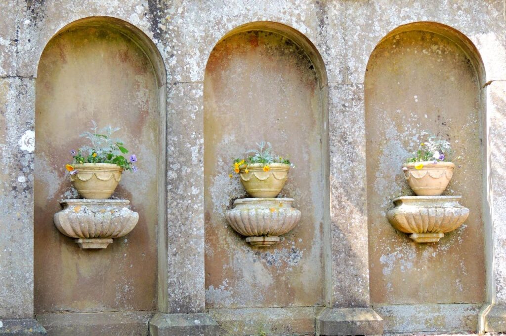 Granite stone planters with ornamental grasses lining a garden path