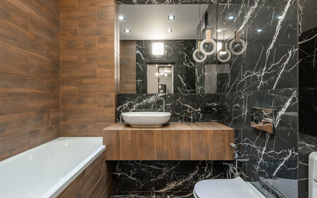 Modern bathroom with wooden vanity and natural stone wall tiles